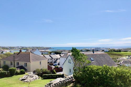 a view of houses and the ocean from a hill at Bodarfor in Trearddur