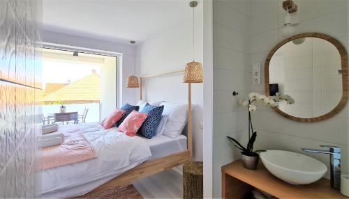 a bedroom with a bed and a mirror and a sink at Mandula Villa in Tihany