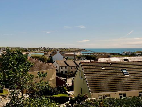 a view of a town with houses and the ocean at Bodarfor in Trearddur