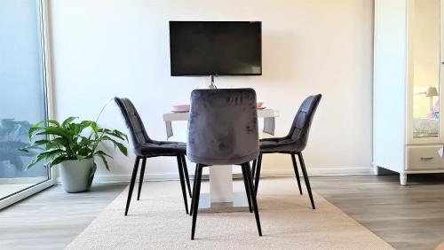 a dining room table with two chairs and a tv at Mandula Villa in Tihany