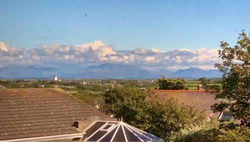 a roof of a building with mountains in the background at Bodarfor in Trearddur