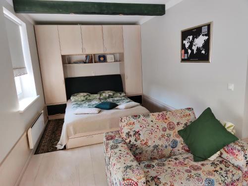 a small bedroom with a bed and a couch at Arte Apartment in Kuressaare