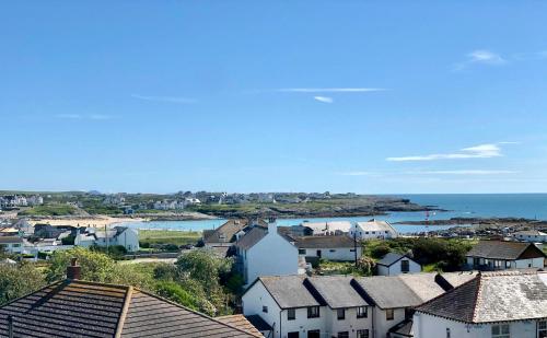 a view of a town with houses and the ocean at Bodarfor in Trearddur