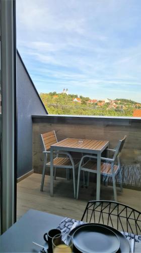 a table and chairs on a balcony with a view at Mandula Villa in Tihany