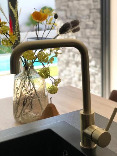 a kitchen sink with a vase with flowers in it at Superb Design Villa Medulin in Medulin