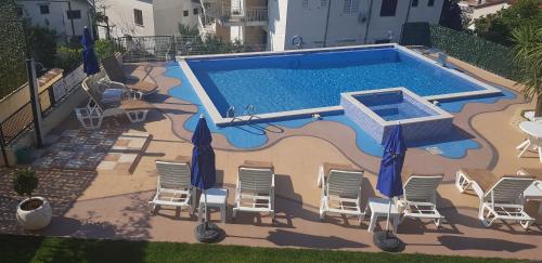 an overhead view of a swimming pool with chairs and umbrellas at Apartmani Niksic in Herceg-Novi