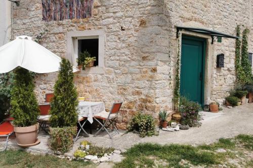 a table with an umbrella in front of a building at Casa Porta Verde in Bale