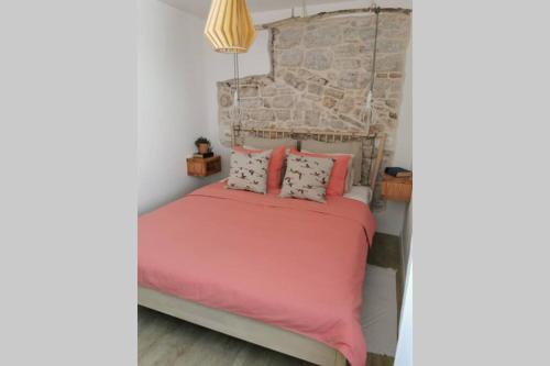 a bedroom with a bed with pink sheets and pillows at Casa Porta Verde in Bale