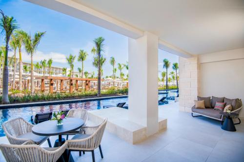 a patio with a table and chairs next to a pool at Hyatt Zilara Cap Cana - Adults Only in Punta Cana