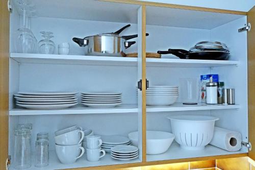 a cabinet filled with plates and bowls and dishes at Charmantes, gemütliches Studio, im Zentrum - C2 in St. Moritz