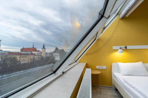 a bedroom with a view of a city from a window at Opera Passage Hotel & Apartments in Lviv