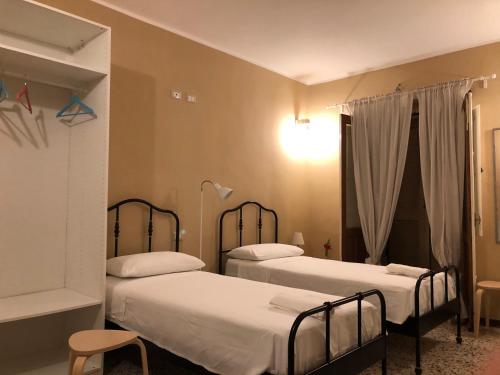 sypialnia z 2 łóżkami i oknem w obiekcie Risveglio nel Borgo w mieście San Donato di Ninea