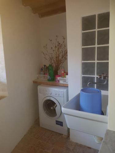 a laundry room with a washing machine and a sink at Casa a Serrazzano in Serrazzano