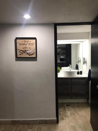 a bathroom with a sink and a mirror at Tu Depa en el Paraiso Cancún in Cancún