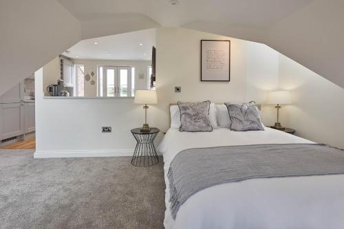 um quarto branco com uma cama e um espelho em Host & Stay - The Birds Nest em Whitby