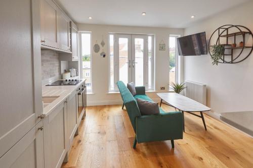 uma cozinha com uma mesa, uma cadeira verde e uma mesa em Host & Stay - The Birds Nest em Whitby