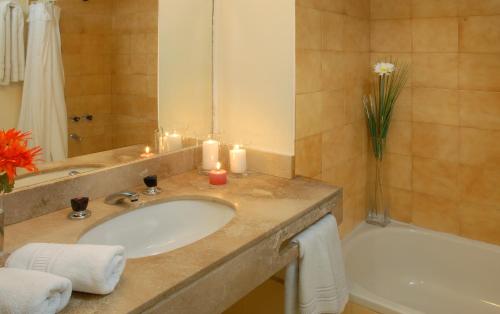 uma casa de banho com um lavatório, uma banheira e velas em Soft Bariloche Hotel em San Carlos de Bariloche