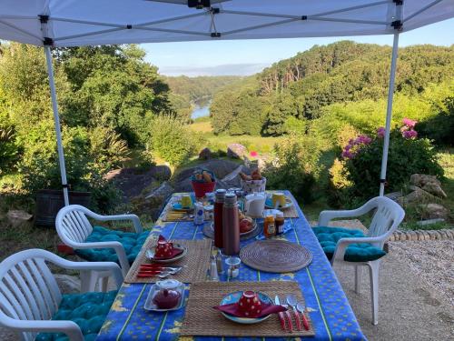 un tavolo con sopra del cibo sotto un ombrello di Moulin des Baleines de Kérandraon Plouguerneau a Plouguerneau