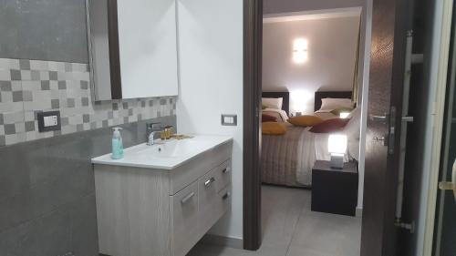 un bagno con lavandino e una camera con letto di Idilliaco inn a Motta SantʼAnastasia