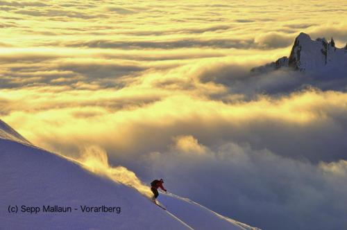 a person is skiing on a mountain above the clouds at Ferienwohnung Düns4 in Düns