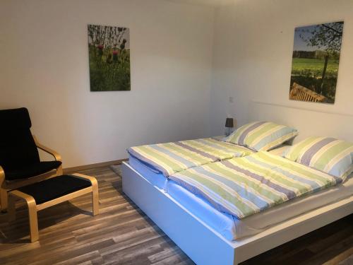 a bedroom with a bed and a chair in it at Ferienhof Kröger in Bielefeld