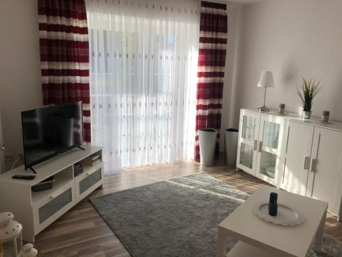 a living room with a flat screen tv and a table at Ferienhof Kröger in Bielefeld