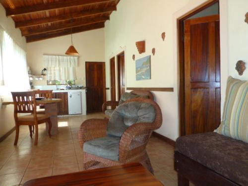 a living room with a couch and chairs and a kitchen at Villa Silvestre in Coco