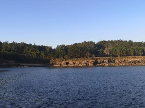 a large body of water with trees in the background at Casa Camariñas in Camariñas