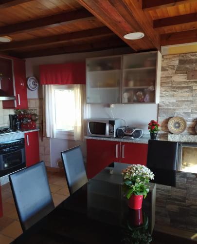 a kitchen with red cabinets and a table with chairs at Casa Camariñas in Camariñas