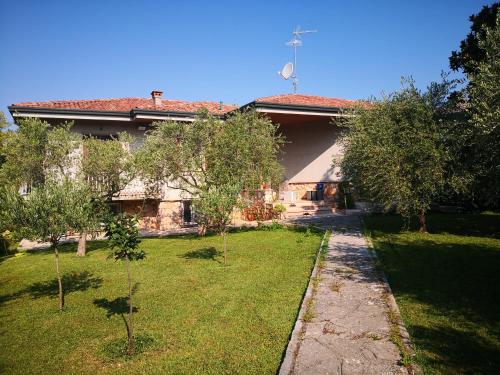 una casa con un patio con árboles delante de ella en Casa Bella, en Ponti Sul Mincio