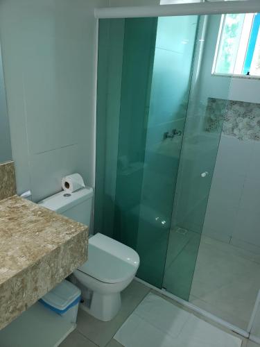 a bathroom with a toilet and a glass shower at Guest House Forno in Búzios