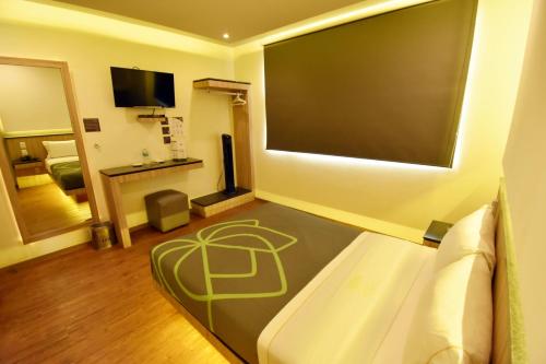 a living room with a couch and a flat screen tv at Hotel Lirio - Adult Only in Mexico City