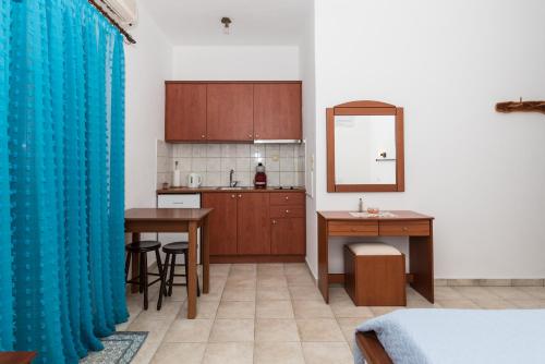 a kitchen with a table and a blue curtain at Vesleme in Pachaina