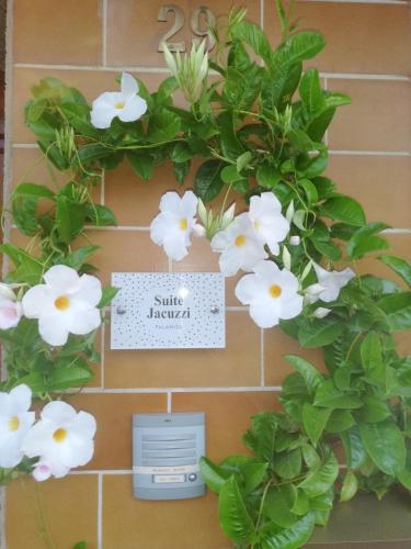 a wreath of white flowers on a wall at Nueva suite jacuzzi relax beach & mountain in Palamós