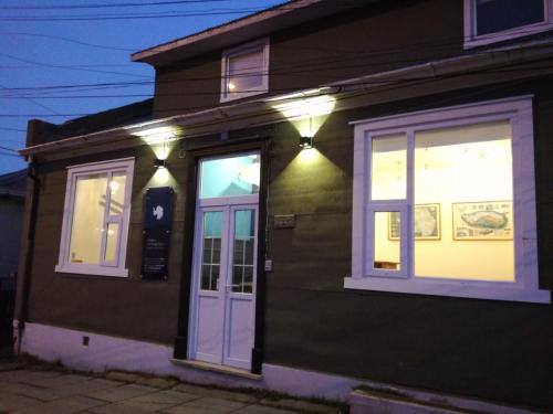 uma casa verde com luzes ao lado em HOSTAL BOUTIQUE TERRA ANTARCTICA em Punta Arenas