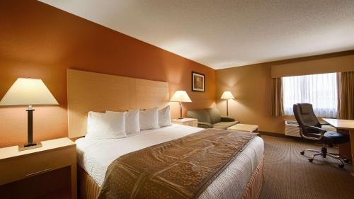 um quarto de hotel com uma cama, uma secretária e uma cadeira em Best Western Paducah Inn em Paducah