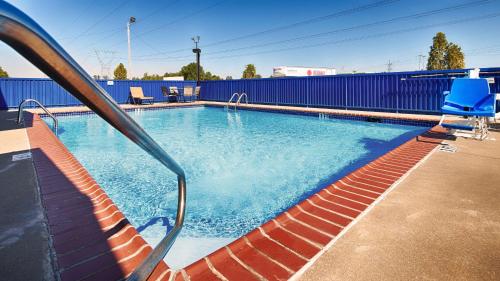 uma piscina com uma cerca azul e cadeiras azuis em Best Western Paducah Inn em Paducah