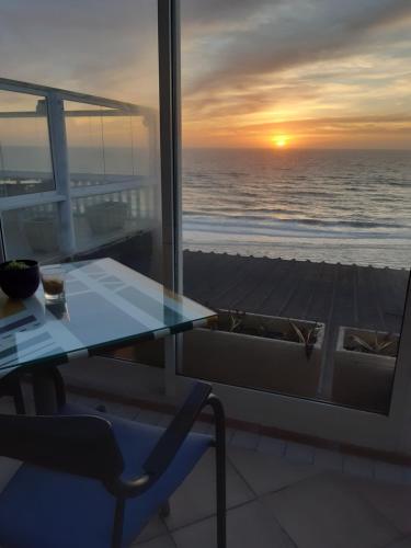 a table with a view of the ocean at sunset at Albergaria Pedra D'Ouro in São Pedro de Moel