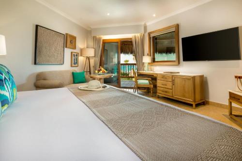 a bedroom with a large white bed and a desk at Valentin Imperial Riviera Maya All Inclusive - Adults Only in Puerto Morelos