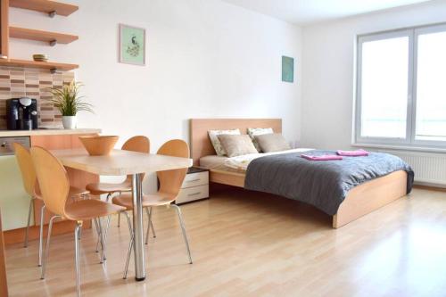 a bedroom with a bed and a table and chairs at Modern apartments - Airport 8mins in Prague