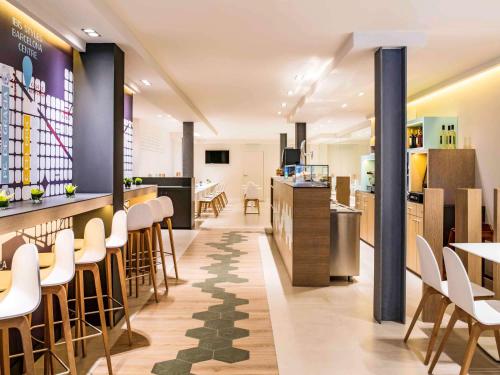 a restaurant with a bar and chairs and a counter at ibis Styles Barcelona Centre in Barcelona