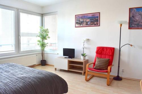 a bedroom with a bed and a chair and a desk at Modern apartments - Airport 8mins in Prague