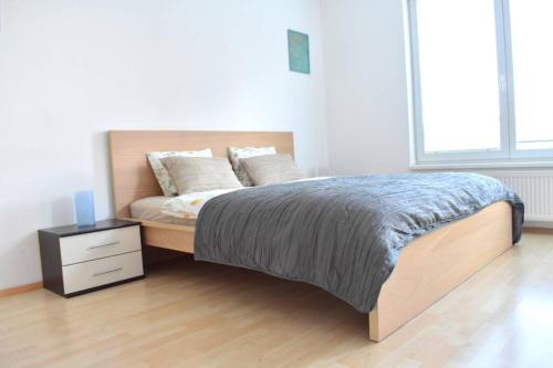 a bedroom with a bed with a nightstand and a bed sidx sidx at Modern apartments - Airport 8mins in Prague