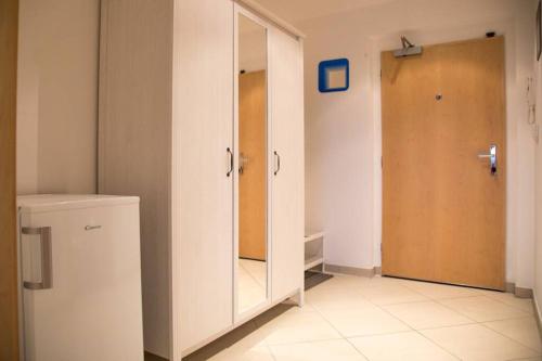a bathroom with a large white cabinet and a mirror at Modern apartments - Airport 8mins in Prague