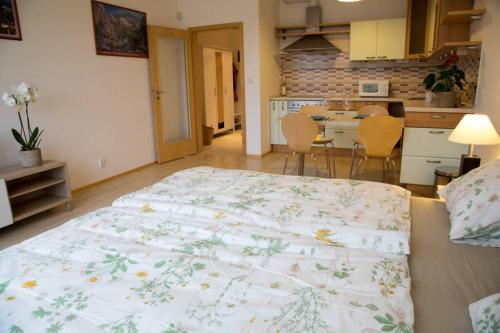 a large bed in a room with a kitchen at Modern apartments - Airport 8mins in Prague