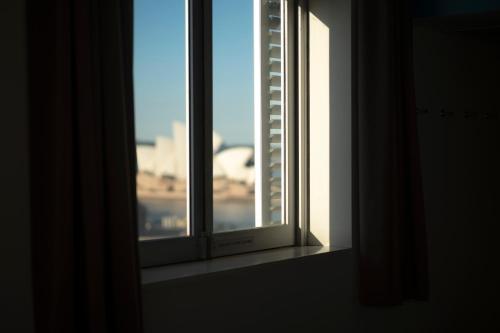 an open window with a view of a building at YHA Sydney Harbour in Sydney