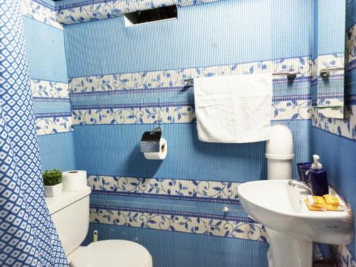 a blue and white bathroom with a toilet and sink at Royalty Inn in Lima