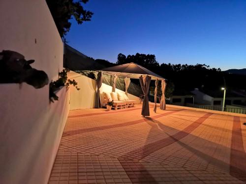 a patio with a gazebo on the side of a house at Casa de Agrelos in Ponte da Barca