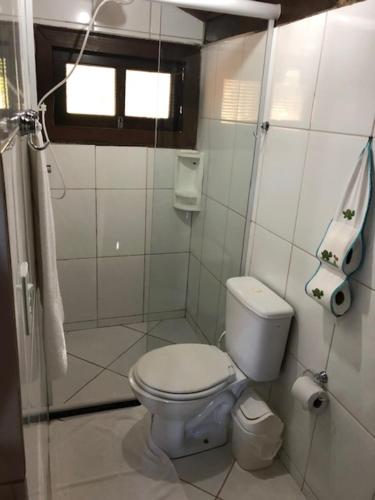 La salle de bains blanche est pourvue de toilettes et d'une fenêtre. dans l'établissement Pousada Jardim da Chapada, à Chapada dos Guimarães