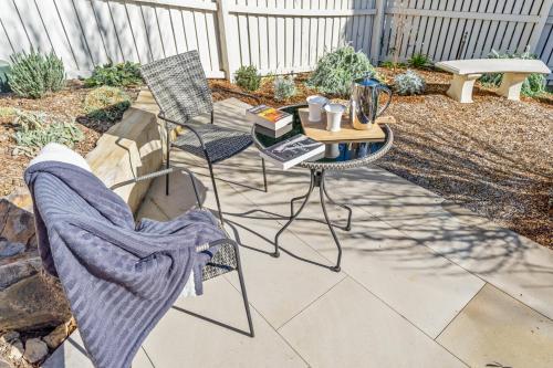 a patio with two chairs and a table with books on it at Hall House in Bowral